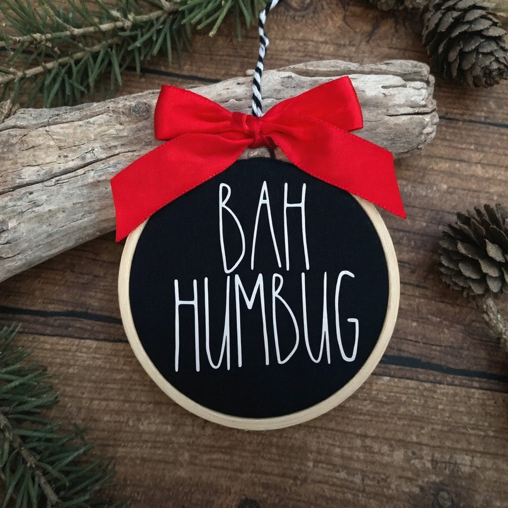 mini Stickrahmen mit weißem Schriftzug Bah Humbug auf schwarzem Grund, Rot Schleife am oberen Rand